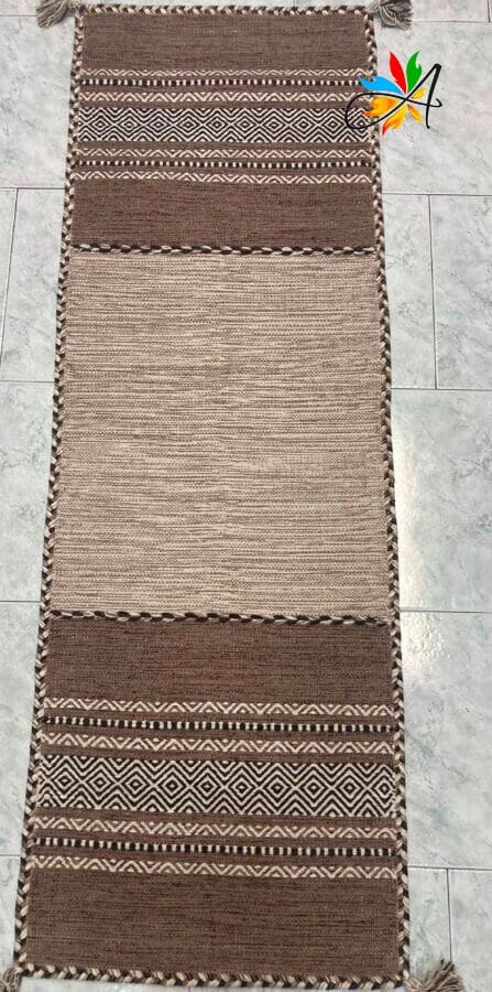 Azerbaijan Tappeti Milano Un tappeto marrone e beige con nappe sul pavimento, disponibile per l'acquisto presso un negozio di tappeti a Milano.