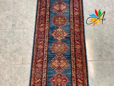 Azerbaijan Tappeti Milano Un lungo tappeto tradizionale con motivi decorati su un pavimento piastrellato.