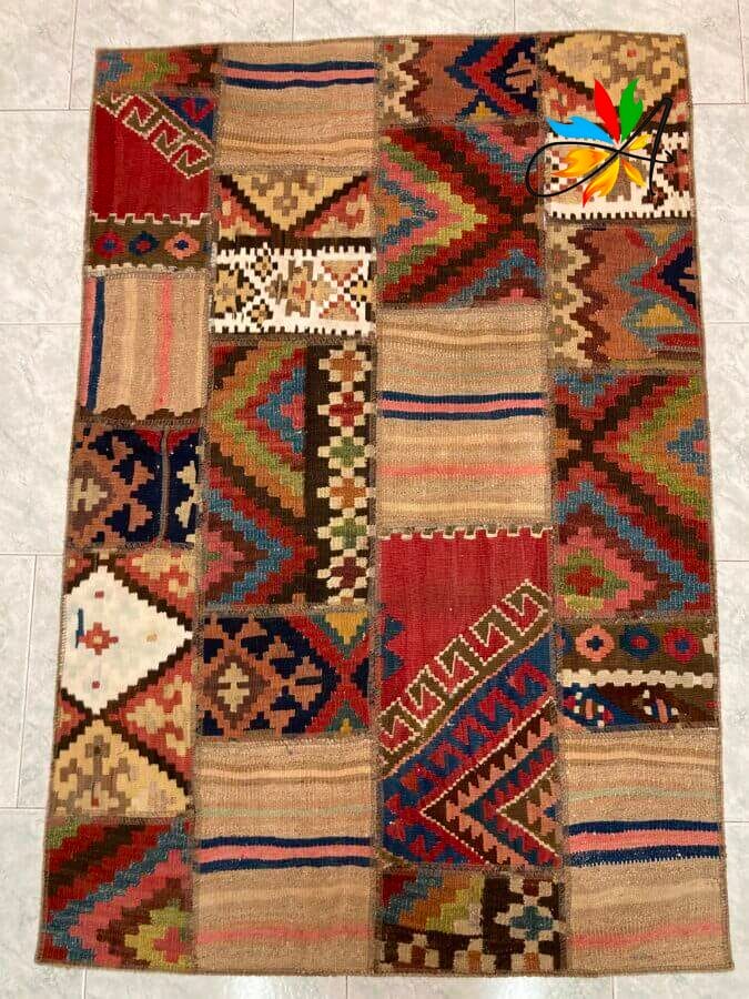 Azerbaijan Tappeti Milano Un tappeto patchwork colorato con vari motivi disposti su un pavimento piastrellato, con una vivace illustrazione di una farfalla aggiunta in un angolo.