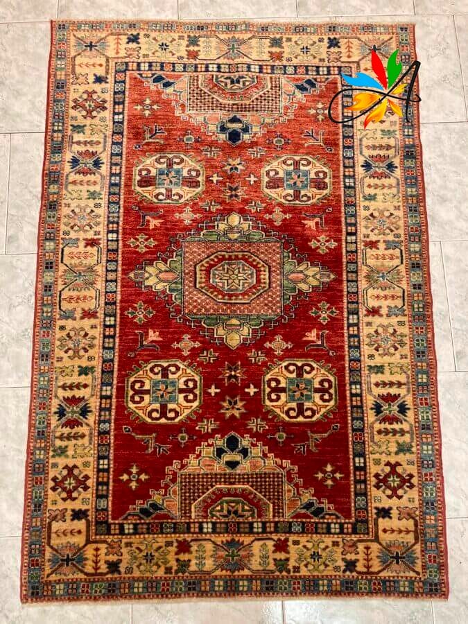 Azerbaijan Tappeti Milano Un vivace tappeto rosso e blu adorna magnificamente un elegante pavimento in piastrelle nel cuore del prestigioso negozio di tappeti di Milano, mettendo in mostra l'eleganza e l'artigianalità dei tappeti persiani e orientali.