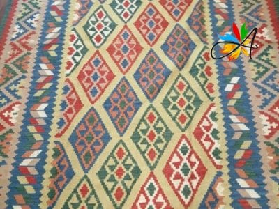 Azerbaijan Tappeti Milano Un vivace tappeto kilim su un pavimento in legno lucido.