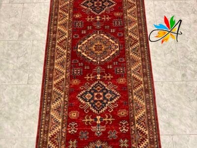 Azerbaijan Tappeti Milano Un lungo tappeto tradizionale con motivi intricati esposti su un pavimento piastrellato.