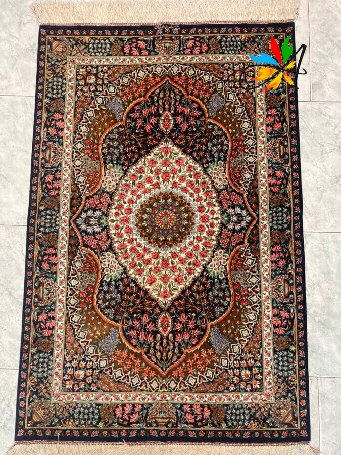Azerbaijan Tappeti Milano Un tappeto orientale decorato con motivi intricati e un colorato disegno a girandola, disposto su un pavimento piastrellato.