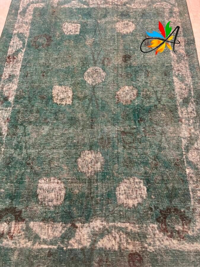 Azerbaijan Tappeti Milano Un tappeto verde con un disegno floreale, disponibile presso il nostro negozio di Milano.