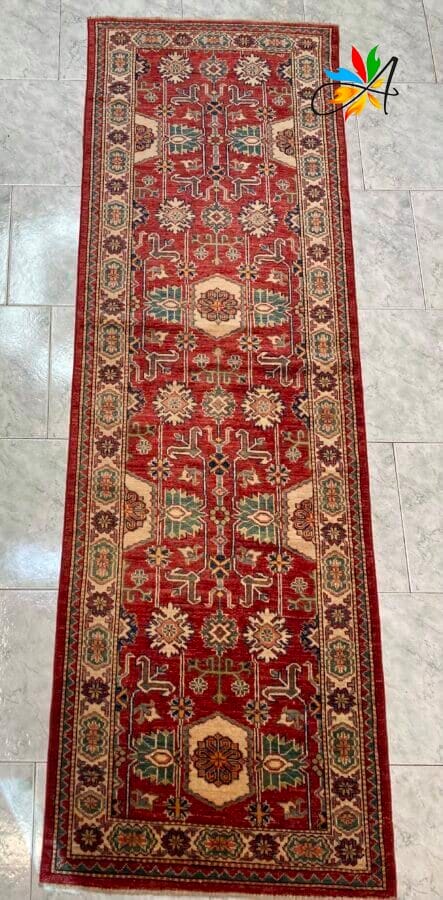 Azerbaijan Tappeti Milano Un vivace tappeto rosso aggiunge un tocco di colore all'elegante pavimento in piastrelle.