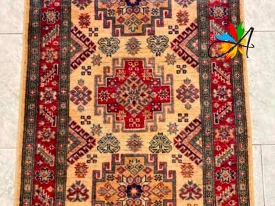 Azerbaijan Tappeti Milano Un tappeto a motivi tradizionali con una spilla a forma di farfalla posizionata nell'angolo in alto a destra.