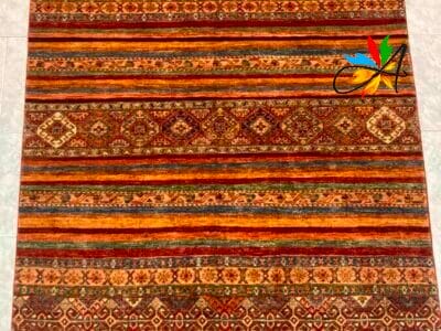 Azerbaijan Tappeti Milano Un tappeto a motivi con un oggetto a forma di foglia nell'angolo in alto a destra.