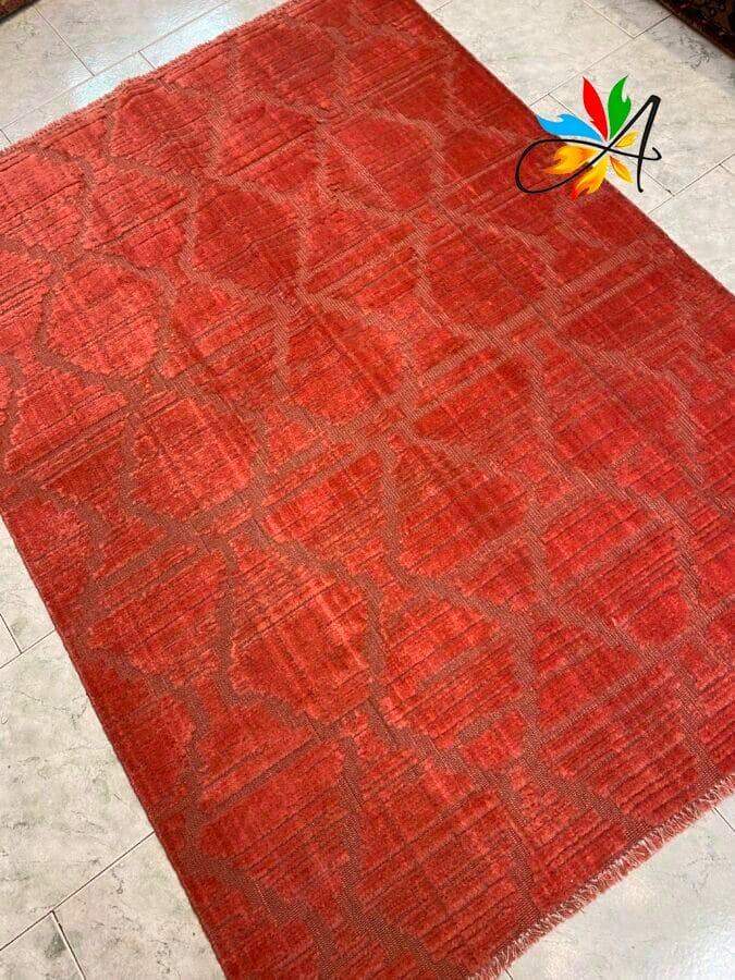 Azerbaijan Tappeti Milano Un tappeto rosso con un delicato motivo geometrico su un pavimento piastrellato.