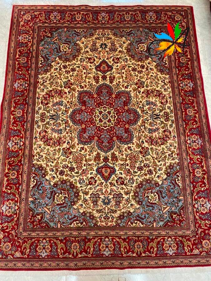 Azerbaijan Tappeti Milano Un tappeto persiano decorato con un motivo floreale dettagliato nei toni del rosso, del blu e del beige.