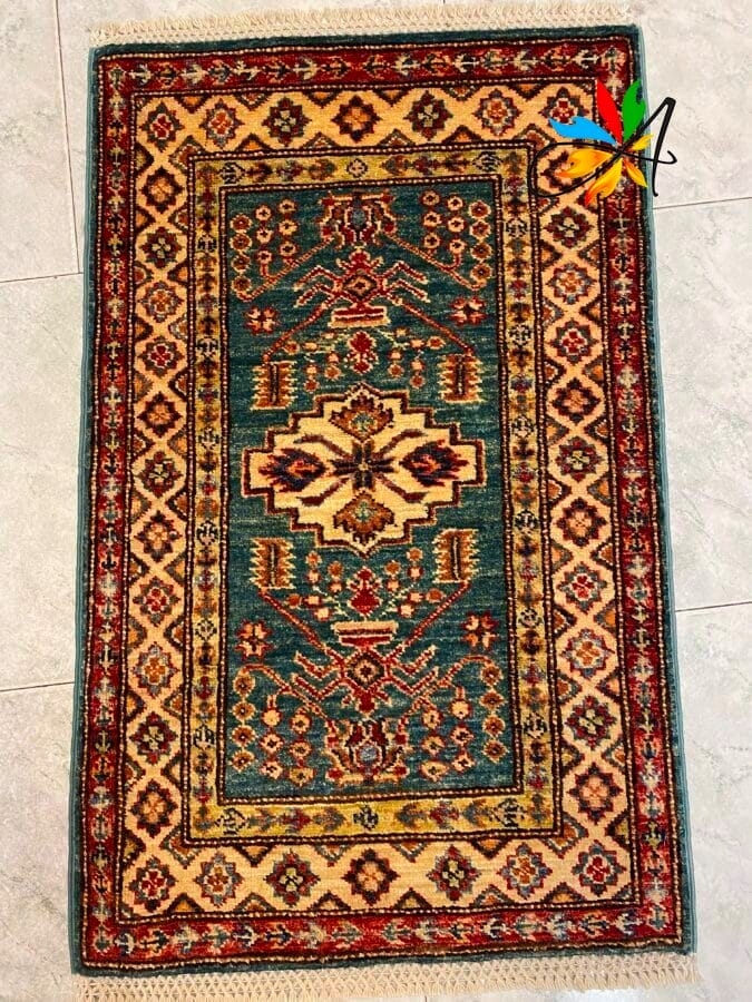 Azerbaijan Tappeti Milano Un piccolo tappeto rettangolare decorato con motivi geometrici nei toni del verde acqua, crema, rosso e oro.
