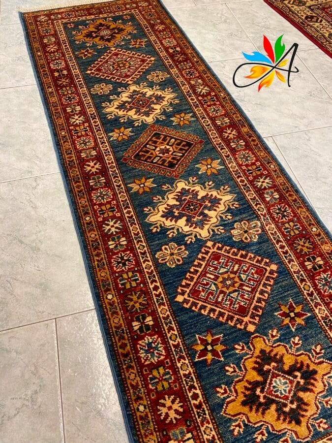 Azerbaijan Tappeti Milano Un tappeto orientale decorato con motivi geometrici e floreali su un pavimento piastrellato.