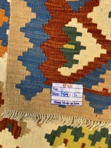 Azerbaijan Tappeti Milano Primo piano dell'etichetta di un tappeto fatto a mano che ne indica l'origine dall'Iran, con un motivo a farfalla nell'angolo in alto a destra.