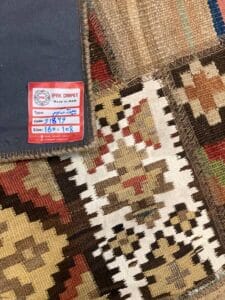 Azerbaijan Tappeti Milano Una selezione di tappeti tradizionali piegati con un'etichetta che ne indica uno prodotto in Iran.