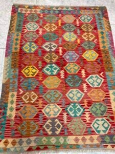 Azerbaijan Tappeti Milano Un tappeto colorato e fantasia con una decorazione a farfalla posizionata sopra.