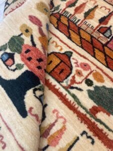 Azerbaijan Tappeti Milano Un primo piano di un tappeto con tanti disegni diversi, in vendita presso un negozio specializzato in tappeti persiani a Milano.
