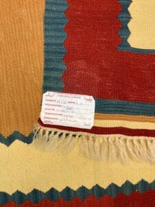 Azerbaijan Tappeti Milano Un tappeto tessuto a mano con un'etichetta che ne descrive la natura artigianale, l'origine dall'Egitto e la composizione del materiale.