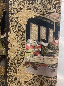 Azerbaijan Tappeti Milano Una copertina di libro riccamente decorata con una rappresentazione intrecciata di una scena classica con figure in abiti storici.