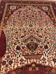 Azerbaijan Tappeti Milano Un tappeto rosso e bianco con un disegno floreale, disponibile presso il nostro negozio di Milano.