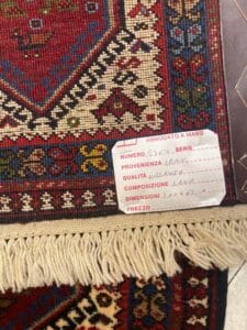 Azerbaijan Tappeti Milano Un tappeto con un'etichetta pubblicitaria del negozio tappeti Milano.