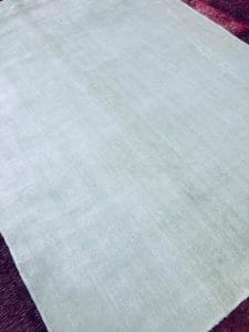 Azerbaijan Tappeti Milano Un tappeto bianco sopra un pavimento in legno, perfetto per chi cerca Tappeti Orientali Milano o Tappeti Persiani Milano poiché offriamo tappeti in vendita di alta qualità
