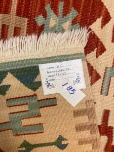 Azerbaijan Tappeti Milano Un tappeto kilim con un'etichetta disponibile per l'acquisto presso un rinomato negozio di tappeti a Milano.