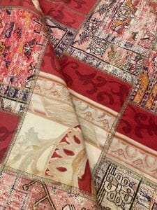 Azerbaijan Tappeti Milano Primo piano di un tessuto a motivi rossi e beige disponibile per la vendita presso un negozio di tappeti a Milano.