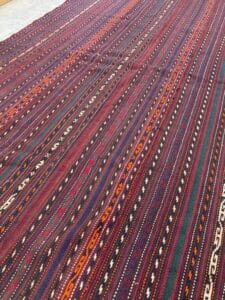 Azerbaijan Tappeti Milano Un tappeto kilim turco vintage si adagia con grazia sul pavimento, aggiungendo calore e carattere a qualsiasi spazio.