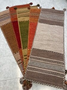 Azerbaijan Tappeti Milano Un gruppo di tappeti orientali colorati con nappe sul pavimento disponibili per la vendita in un negozio di tappeti a Milano.