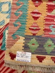 Azerbaijan Tappeti Milano Primo piano di un tappeto persiano colorato, fatto a mano, con un'etichetta che ne indica le dimensioni e l'origine.