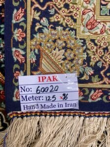 Azerbaijan Tappeti Milano Primo piano di un'etichetta su un tappeto persiano fatto a mano che ne indica il numero di serie e le dimensioni in metri.