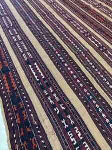 Azerbaijan Tappeti Milano Un grande tappeto kilim afgano su un tavolo disponibile per l'acquisto presso un negozio di tappeti a Milano.