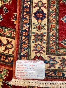 Azerbaijan Tappeti Milano Una sezione dettagliata di un tappeto orientale con un'etichetta che ne riporta le specifiche e il prezzo.