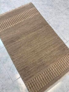 Azerbaijan Tappeti Milano Un tappeto beige su un pavimento piastrellato in un negozio Tappeti Milano.