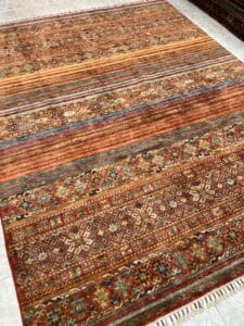 Azerbaijan Tappeti Milano Una serie di tappeti a motivi tradizionali su un pavimento piastrellato.