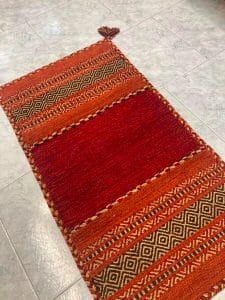 Azerbaijan Tappeti Milano Un tappeto rosso e marrone sul pavimento in vendita a Milano.