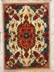 Azerbaijan Tappeti Milano Un tappeto colorato in stile persiano con motivi floreali e un medaglione centrale, posto su un pavimento piastrellato.