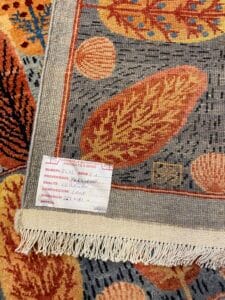 Azerbaijan Tappeti Milano Primo piano di un tappeto colorato con un'etichetta che riporta dettagli come origine, dimensioni e composizione.