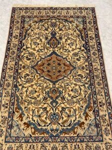 Azerbaijan Tappeti Milano Tappeto persiano rettangolare ornato con intricati motivi floreali blu, marroni e beige su un pavimento piastrellato.