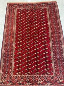 Azerbaijan Tappeti Milano Tappeto rosso con disegni geometrici e motivi bianchi, marroni e neri.