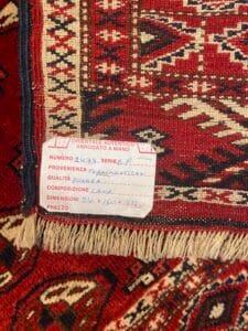 Azerbaijan Tappeti Milano Primo piano di un tappeto a fantasia rossa con un'etichetta che ne descrive l'origine, la qualità, la composizione e le dimensioni.