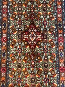 Azerbaijan Tappeti Milano Tappeto in stile persiano, ornato e colorato, con medaglione centrale e una farfalla arcobaleno nell'angolo in alto a destra.