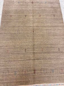 Azerbaijan Tappeti Milano Un tappeto beige con delicati motivi geometrici e un logo colorato nell'angolo in alto a destra su uno sfondo chiaro.