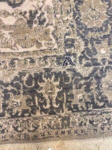 Azerbaijan Tappeti Milano Tappeto grigio e beige con fantasia intricata, con frange parziali sul bordo inferiore. Logo ricamato colorato con un motivo a foglia nell'angolo in alto a destra.