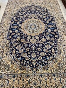 Azerbaijan Tappeti Milano Tappeto rettangolare decorato con intricati motivi floreali nei toni del blu e del beige, caratterizzato da un motivo a medaglione centrale.