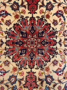 Azerbaijan Tappeti Milano Intricati motivi floreali e geometrici in rosso, blu e nero su sfondo beige, con un motivo a farfalla colorata nell'angolo in alto a destra.