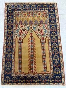 Azerbaijan Tappeti Milano Tappeto orientale rettangolare con disegno centrale a mihrab, caratterizzato da intricati motivi floreali e geometrici nei toni del rosso, del blu, dell'oro e dell'avorio e da un bordo decorativo con motivi ripetuti.