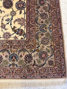 Azerbaijan Tappeti Milano Tappeto persiano dettagliato e decorato con motivi floreali nei toni del rosso, blu, verde e giallo, con bordo beige e frange bianche. Nell'angolo in alto a destra è ricamata una foglia colorata.