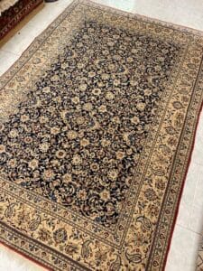 Azerbaijan Tappeti Milano Tappeto rettangolare decorato con intricati motivi floreali nei toni del blu scuro e del beige.