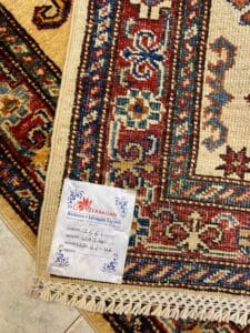 Azerbaijan Tappeti Milano Un colorato tappeto orientale con un'etichetta di servizio attaccata a un angolo, che mostra dettagli scritti a mano.