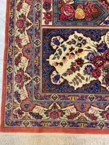 Azerbaijan Tappeti Milano Tappeto con intricati motivi floreali nei toni del blu, rosa e crema, con frange beige lungo il bordo.